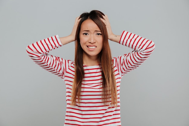 Free photo portrait of a confused asian girl standing