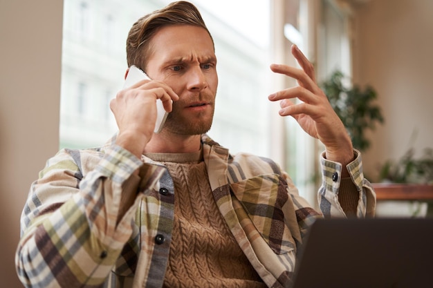 Portrait of confused man arguing with someone over the phone businessman discuss project looking at