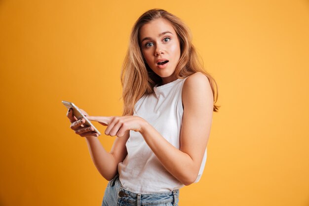 Портрет путать молодая девушка держит мобильный телефон