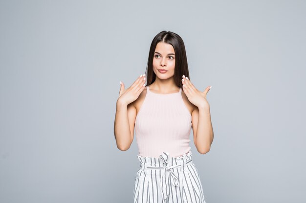 Portrait of confused young girl over white wall