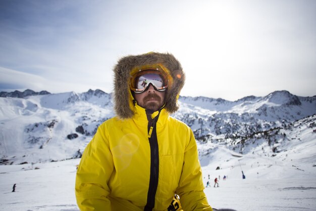 Портрет крутого и грубого сноубордиста или лыжника, или альпиниста в теплой зимней желтой куртке