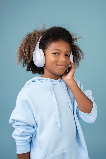 Portrait of cool teenage boy listening to music on headphones