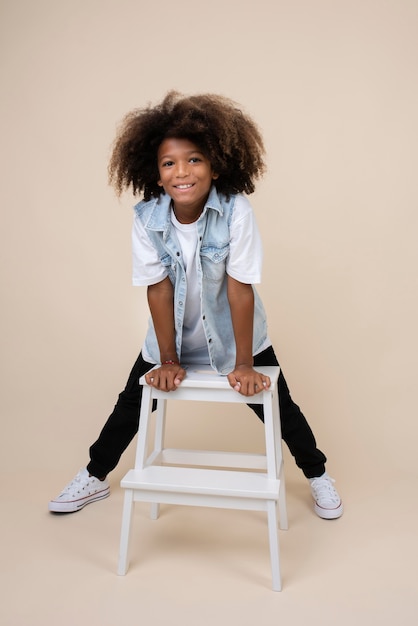 Portrait of cool teenage boy posing on chair