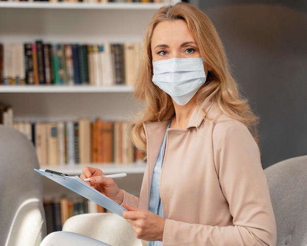 Free photo portrait of counselor with mask in therapy office