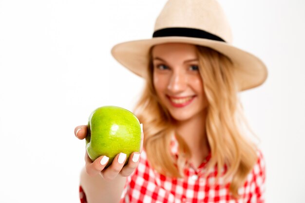 Portrait of country woman with apple on white.