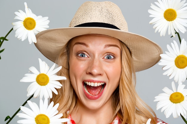 Free photo portrait of country woman with chamomiles on gray.