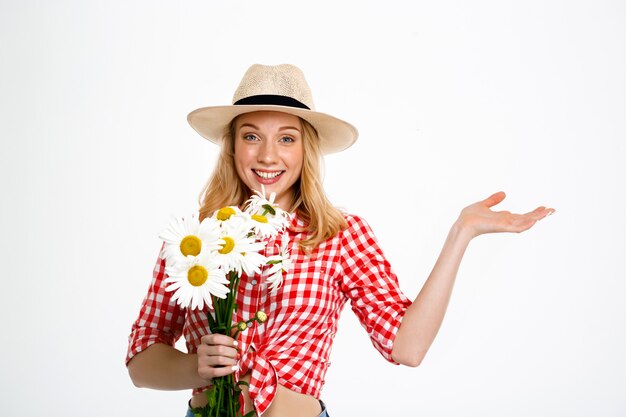 Portrait of country woman with chamomiles on white.