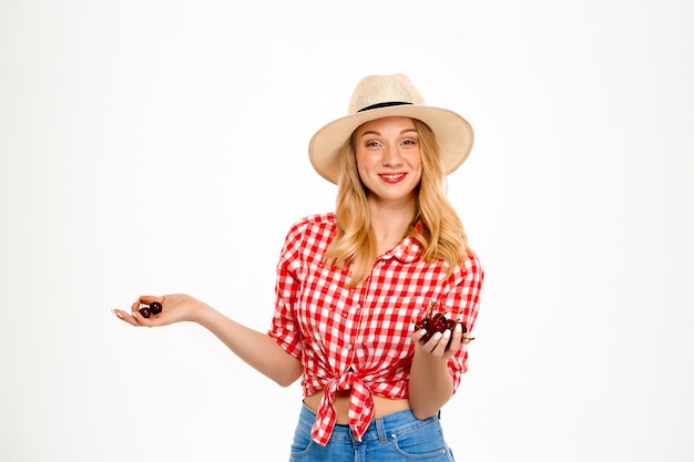 Portrait of country woman with cherry on white.