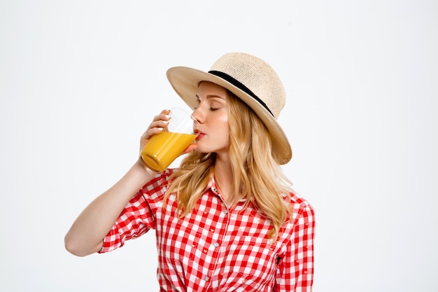 Ritratto della donna del paese con succo su bianco.