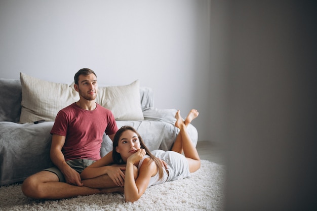 Portrait of couple at home together sitting on floor by the coach