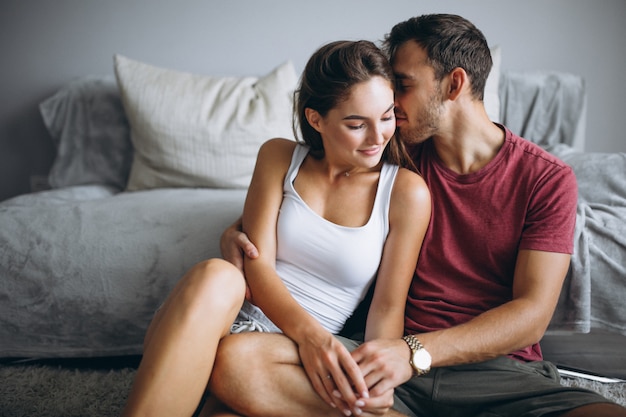 Portrait of couple at home together sitting on floor by the couch