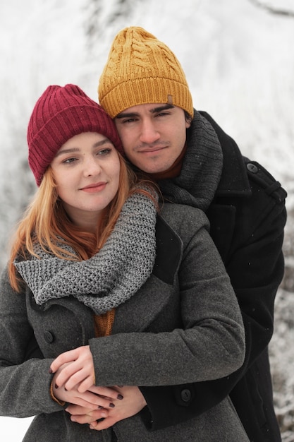 Free photo portrait of couple hugging outdoors in winter season