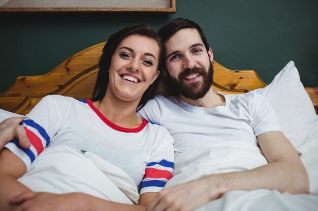 Portrait of couple lying together on bed