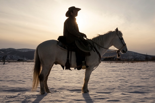 Foto gratuita ritratto di cowboy a cavallo