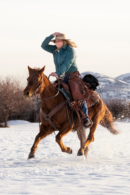 Foto gratuita ritratto di cowgirl a cavallo