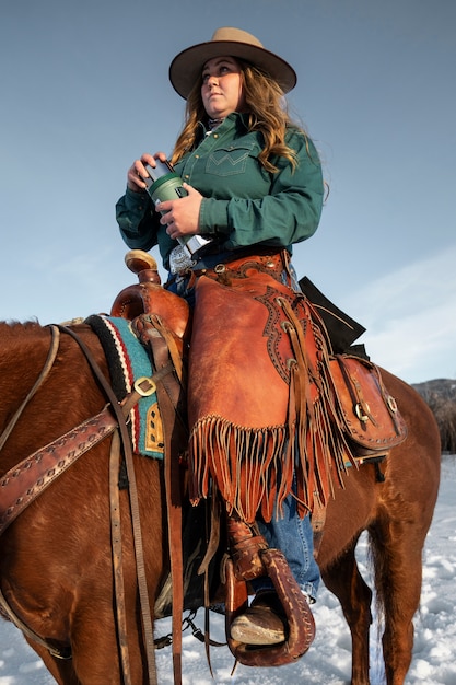 Foto gratuita ritratto di cowgirl a cavallo