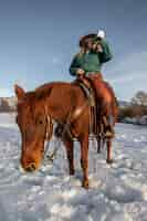 Foto gratuita ritratto di cowgirl a cavallo