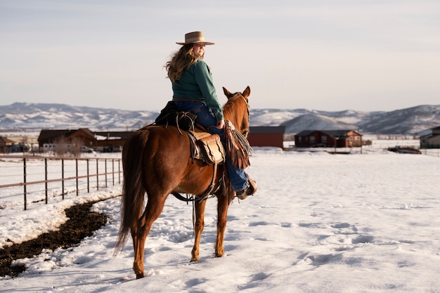 Foto gratuita ritratto di cowgirl a cavallo