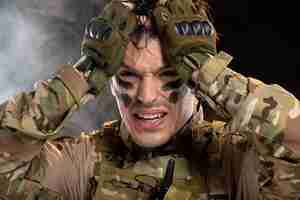 Free photo portrait of crying young soldier in camouflage on black wall