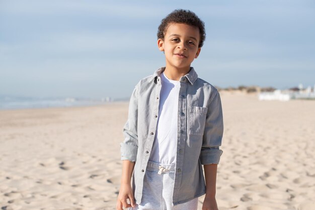 Portrait of cute African American boy on beach