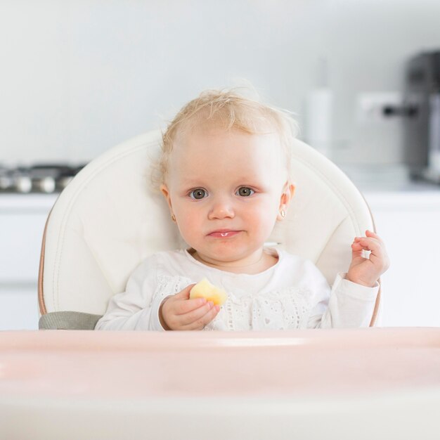 Portrait of cute baby girl in highchair