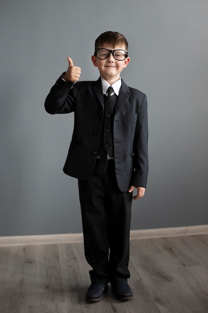 Portrait of cute boy wearing suit and glasses