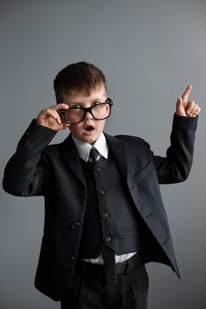 Free photo portrait of cute boy wearing suit and glasses