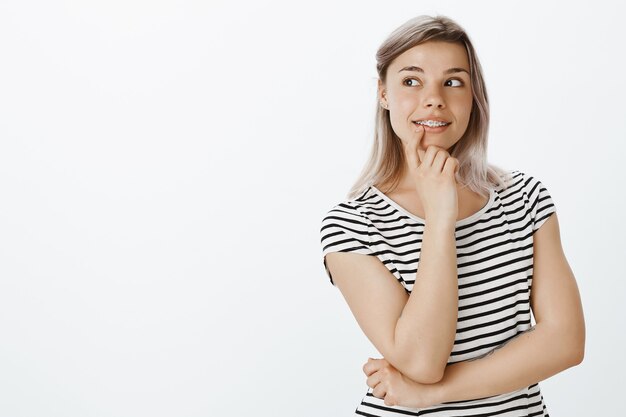 Portrait of cute charming blonde girl posing in the studio