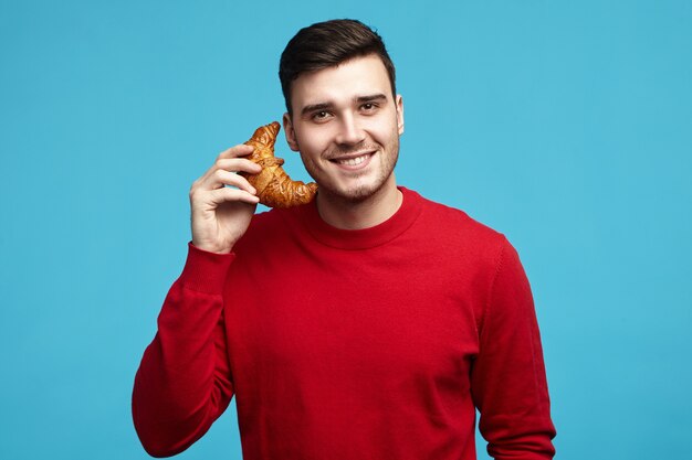 Portrait of cute charming young dark haired unshaven male looking at camera