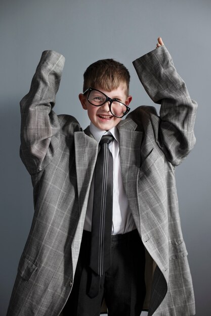 Portrait of cute child with oversized suit and glasses