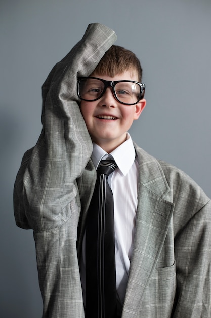 Free photo portrait of cute child with oversized suit and glasses