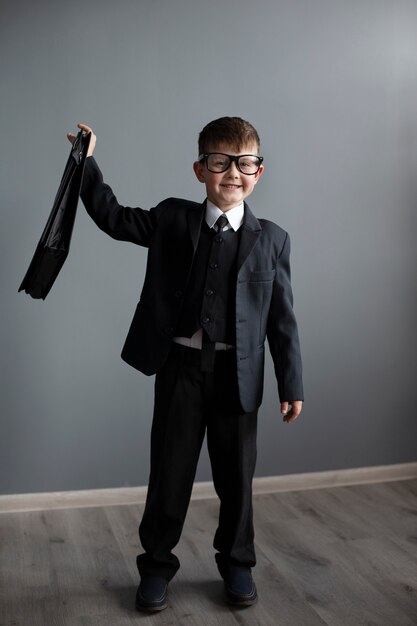 portrait of cute child with suit and briefcase