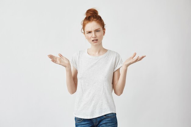 Portrait of cute displeased redhead woman gesturin