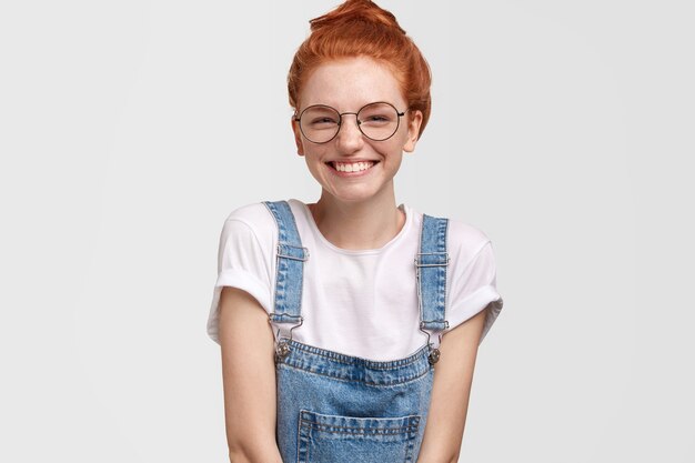 Portrait of cute ginger woman in overalls