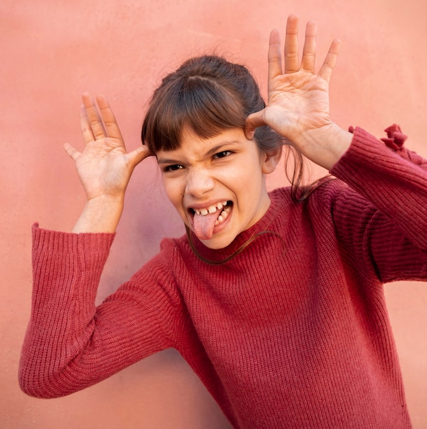 Foto gratuita ritratto di ragazza carina che fa una faccia divertente