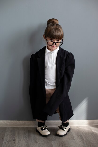 Portrait of cute girl in oversized coat and glasses