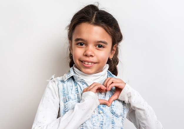 Portrait cute girl showing heart shape