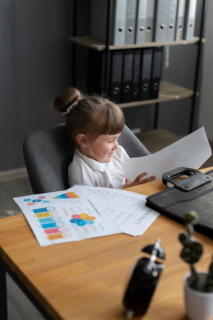 Free photo portrait of cute girl working at her office desk