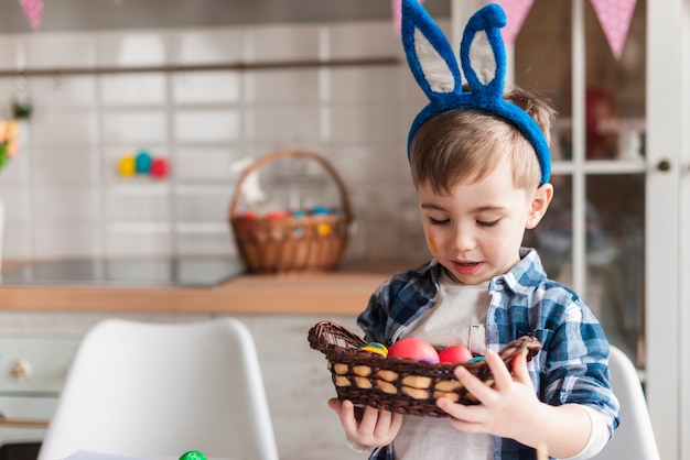 Portrait of cute little boy holding painted eggs