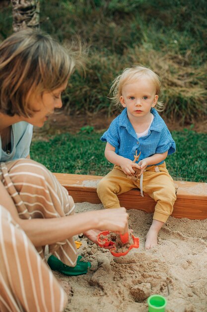 Portrait of cute little girl sitting in sandbox