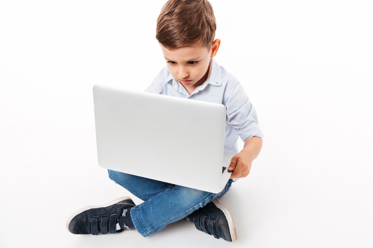 Free Photo portrait of a cute little kid using laptop computer