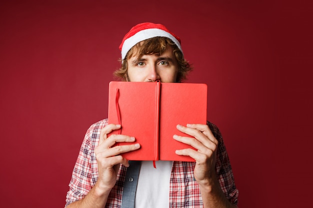 Ritratto di uomo carino nascosto dietro il libro