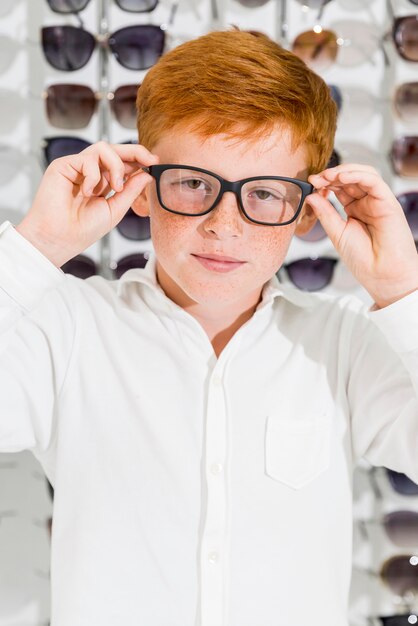 Portrait of cute smiling boy wearing spectacle looking at camera