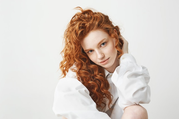 Portrait of cute tender ginger woman with curly hair.