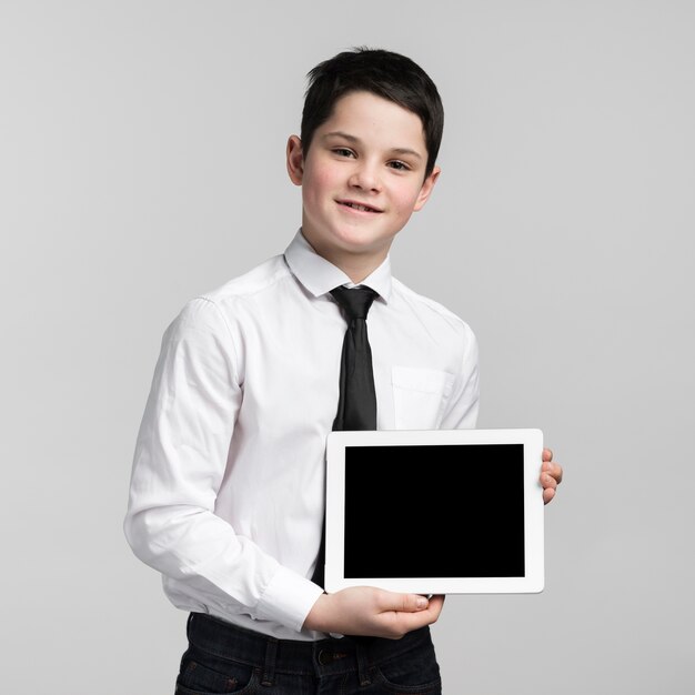 Free photo portrait of cute young boy holding tablet
