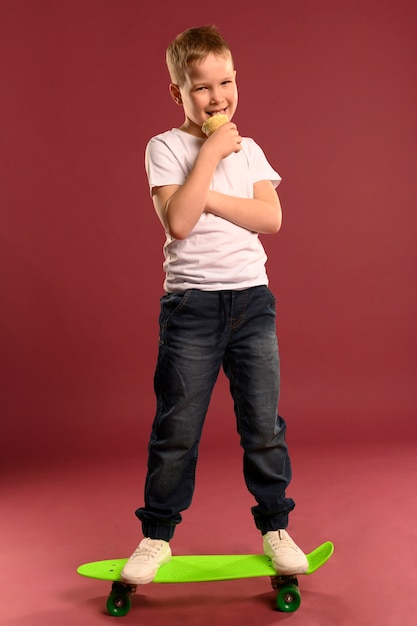 Portrait of cute young boy posing with skateboard