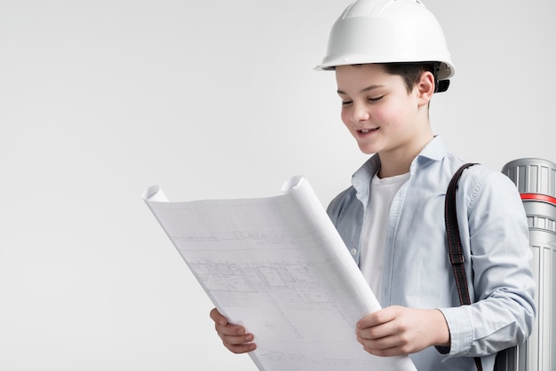 Free photo portrait of cute young engineer reading construction plan