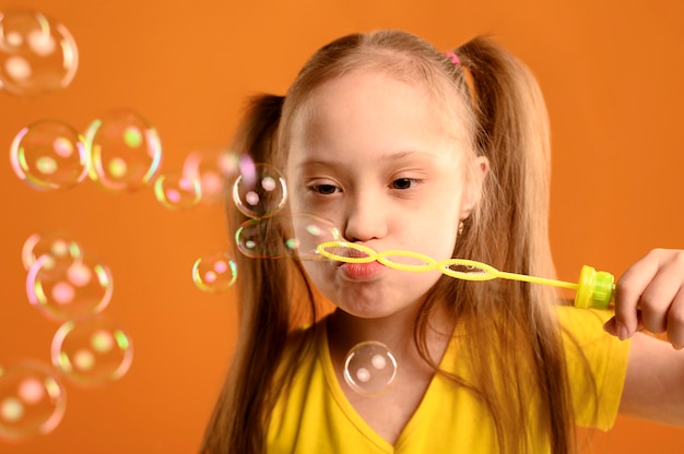 Portrait of cute young girl blowing bubbles