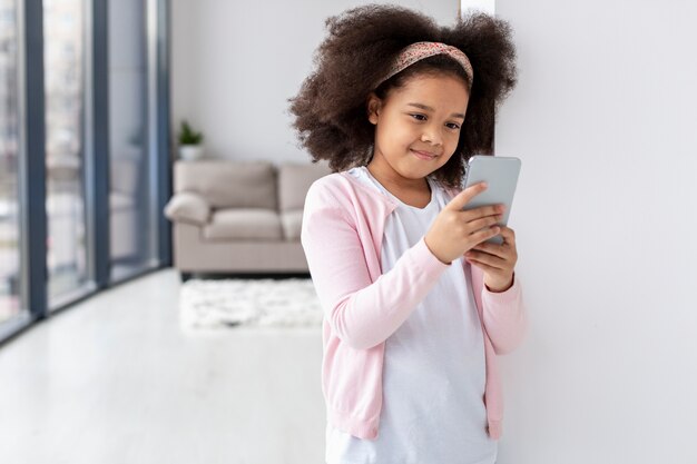 Portrait of cute young girl holding mobile phone