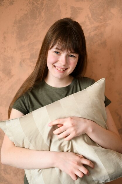 Portrait of cute young girl holding pillow